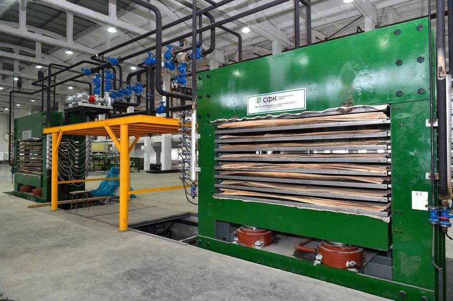 A multi-level hot press loaded with birch plywood panels